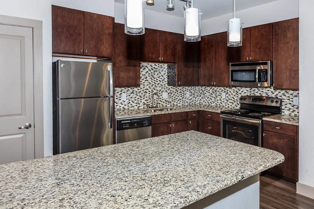 a kitchen with granite counter tops and stainless steel appliances