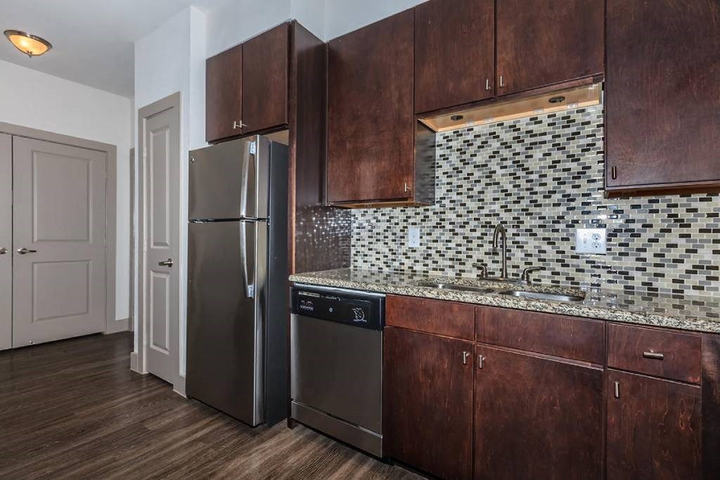 a kitchen with a stainless steel refrigerator and wooden cabinets