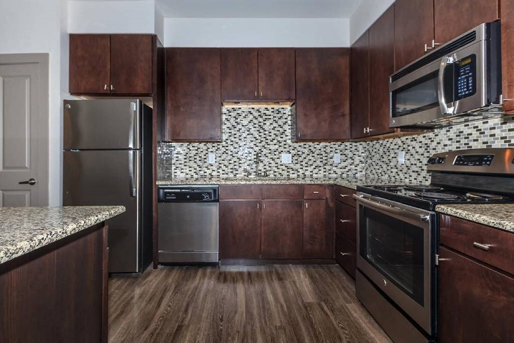 a kitchen with stainless steel appliances and wooden cabinets