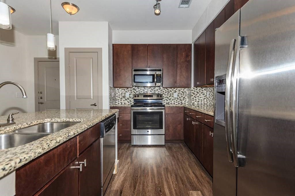 a kitchen with stainless steel appliances and wooden cabinets