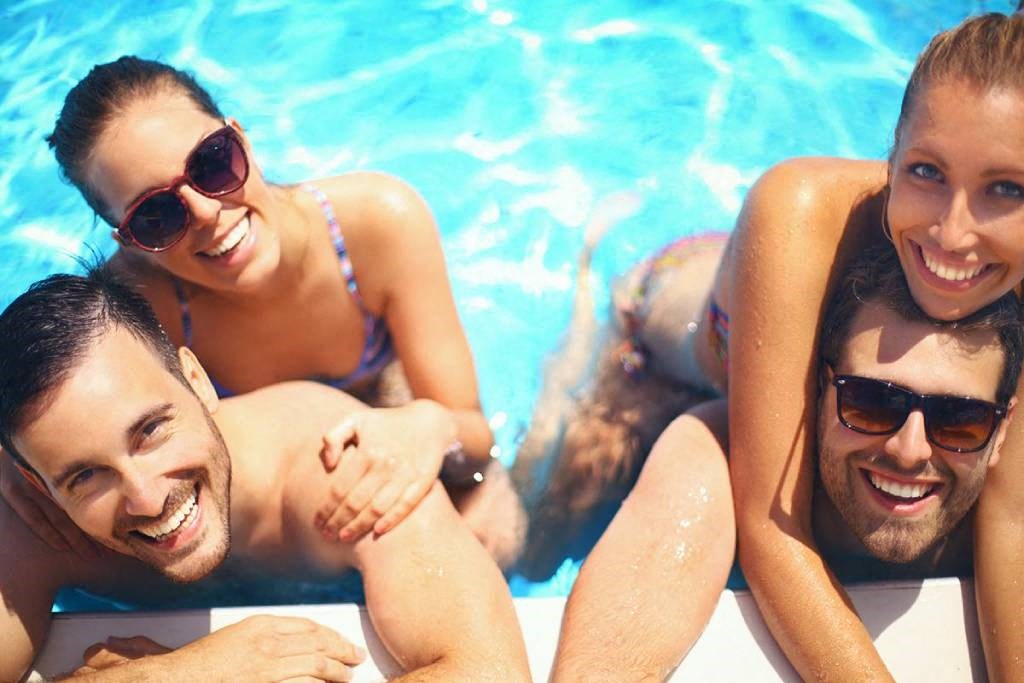 a group of men and women in a swimming pool