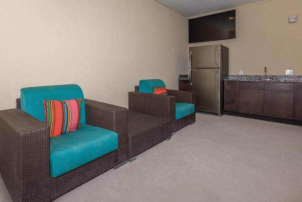 a living room with a couch and chairs and a refrigerator