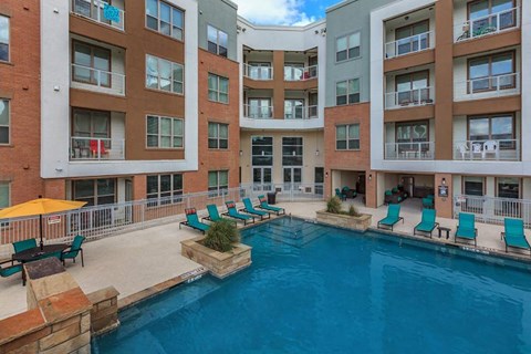 a large swimming pool in front of an apartment building