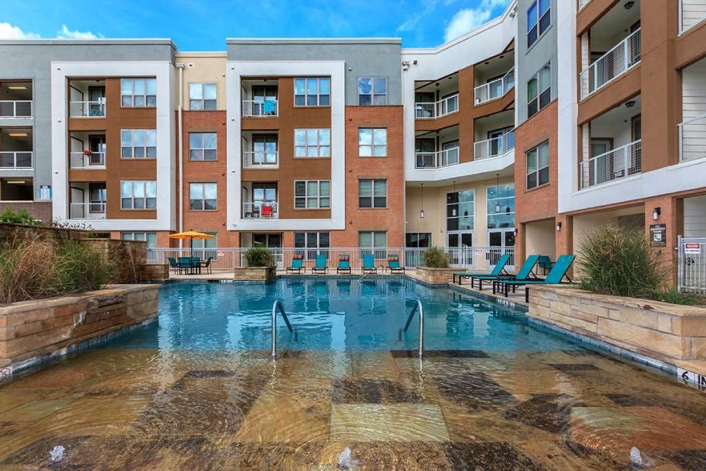 a swimming pool in front of an apartment building