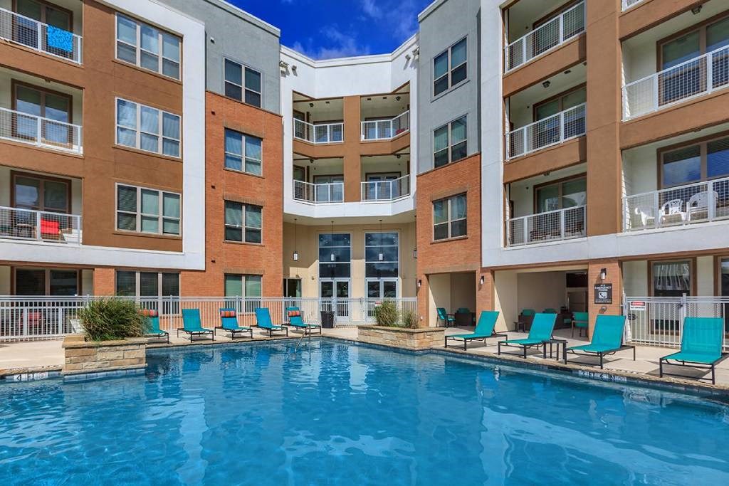 an apartment building with a swimming pool and chairs