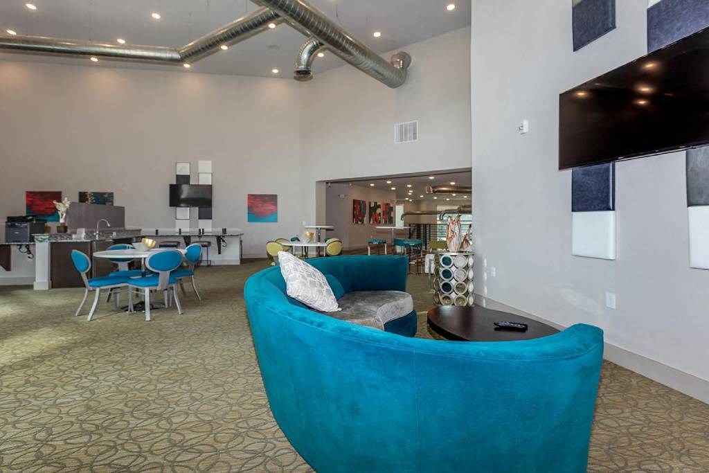 a lobby with a blue couch and a table and chairs