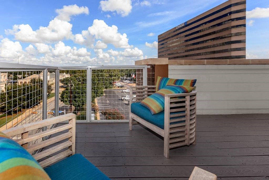 a balcony with a chair and a view of the city