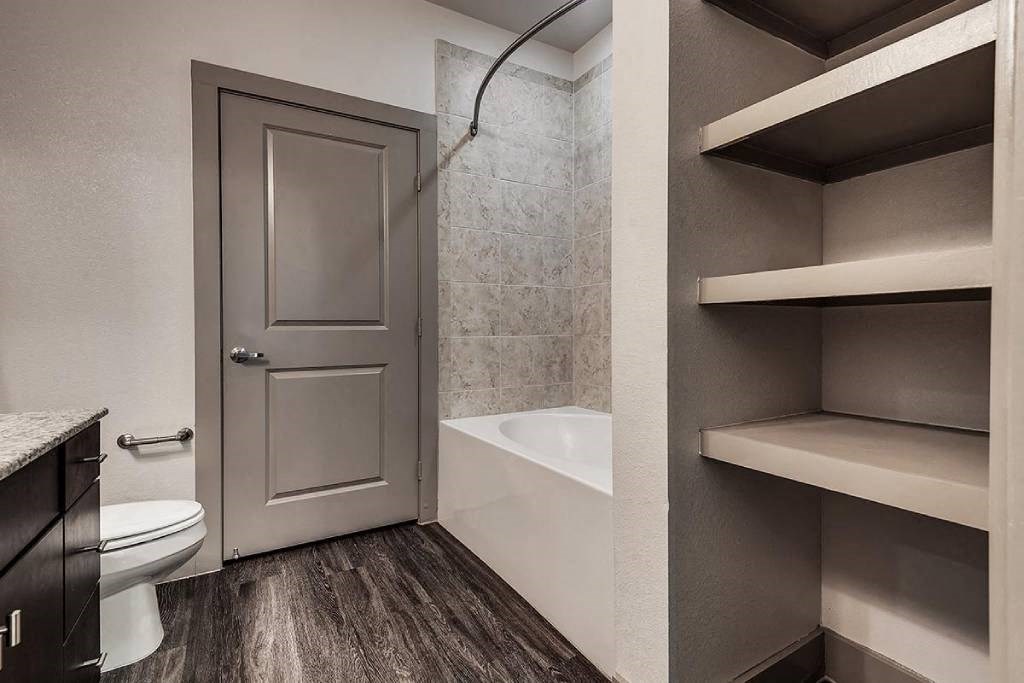 a bathroom with a toilet and a tub and a closet