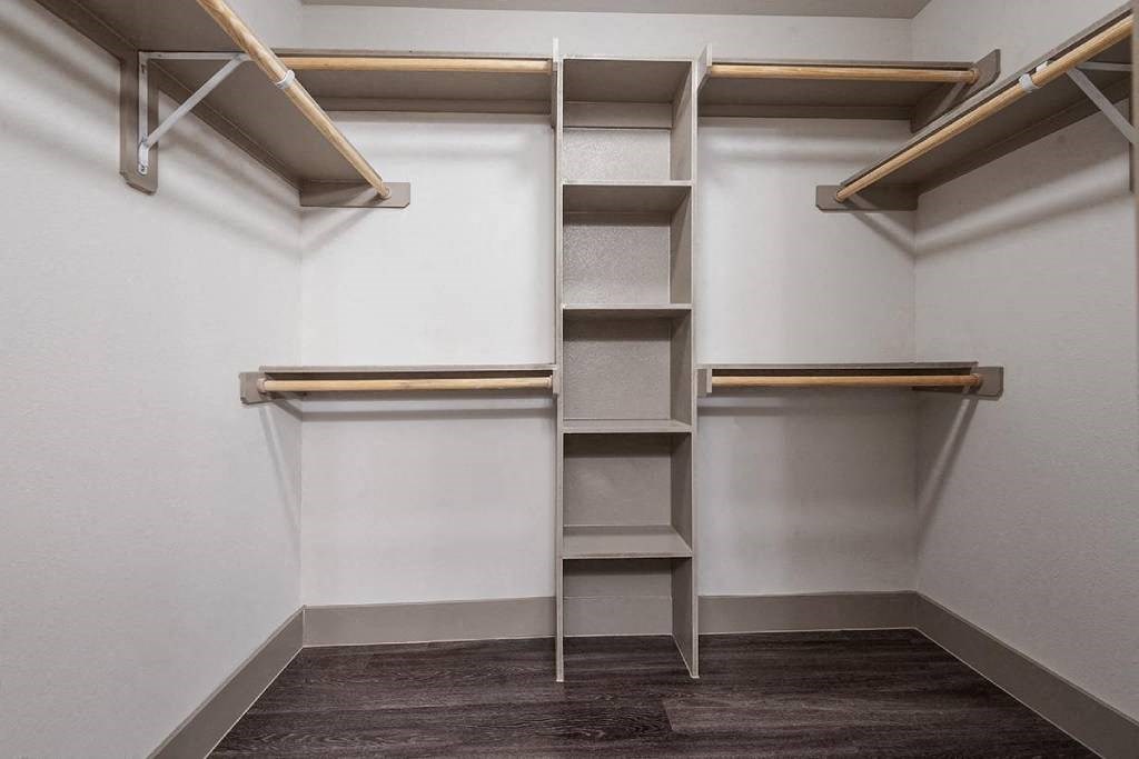 a walk in closet with empty shelves and