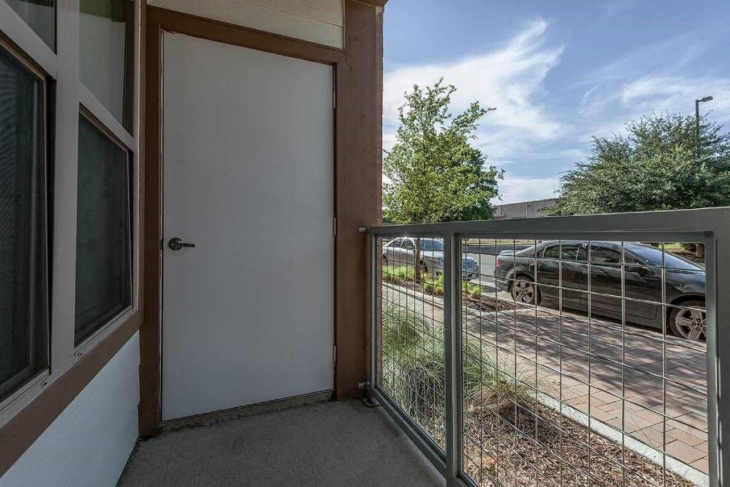 a balcony with a door and a fence      and a car