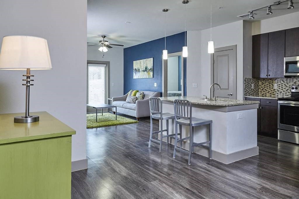 a kitchen with a bar and a living room with a couch