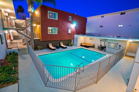 A red building with a pool in front.