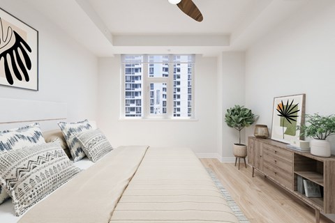 A bedroom with a large bed and a window with a view of a cityscape.