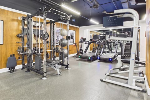 A gym with a variety of equipment including treadmills and weight machines.