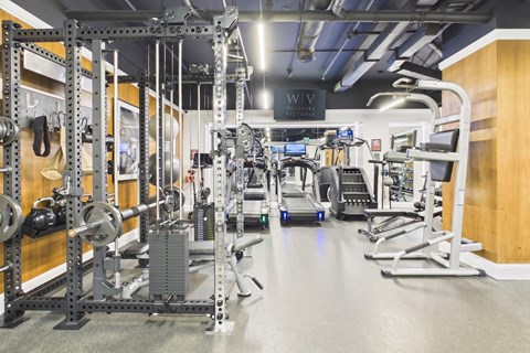 A gym with a variety of equipment including weights and cardio machines.