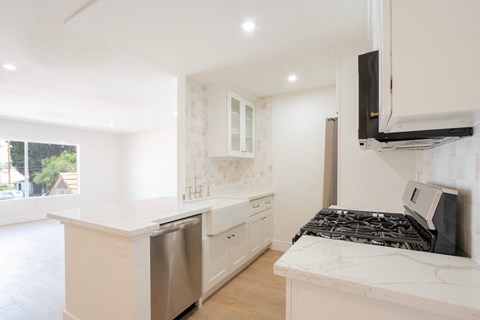 a white kitchen with a stove and a microwave