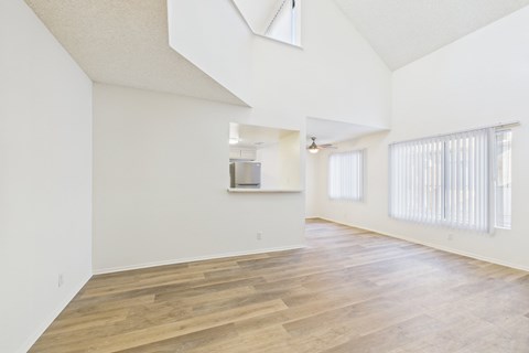 A spacious room with wooden flooring and a skylight.
