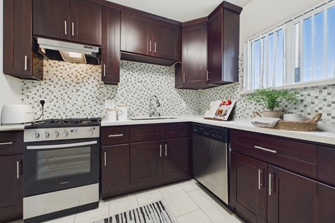 A kitchen with dark brown cabinets and a white stove top oven.