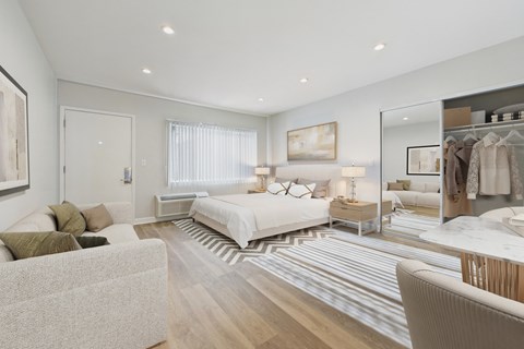 A well-lit bedroom with a large bed and a wardrobe.