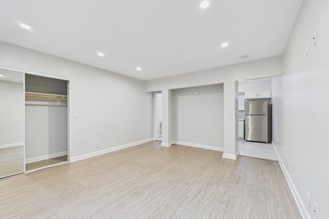 A spacious room with a wooden floor and white walls.