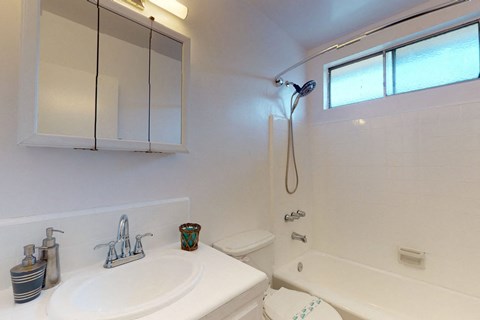 A white bathroom with a sink, toilet, and bathtub.
