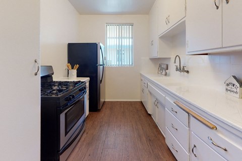 A kitchen with a black stove top oven and white cabinets.