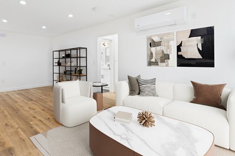 A modern living room with a white couch, a coffee table, and a chair.