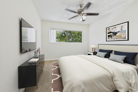 A bedroom with a large bed and a ceiling fan.