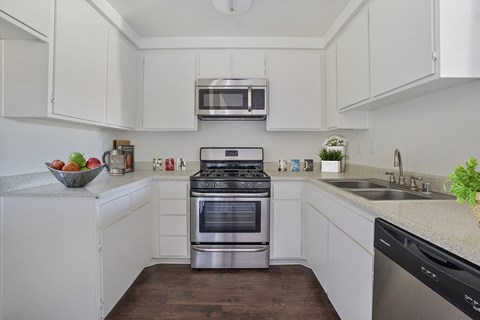 A modern kitchen with white cabinets and stainless steel appliances.