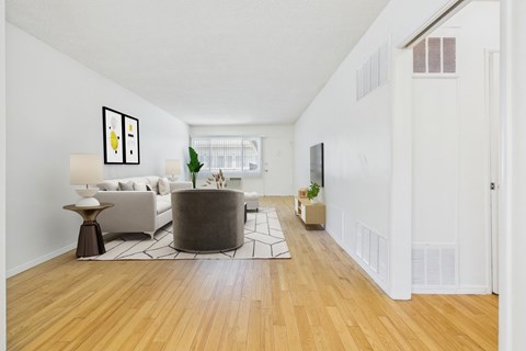A living room with a white couch and a grey ottoman.