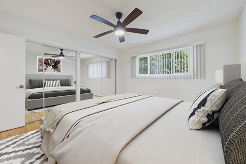 A bedroom with a large bed and a ceiling fan.