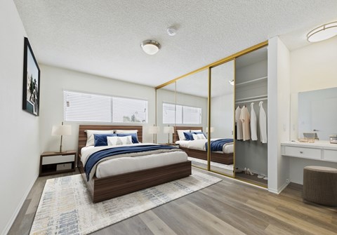 A bedroom with a large bed and a mirrored closet door.