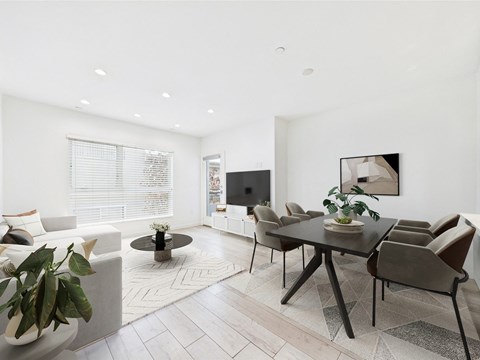 A modern living room with a black table and chairs.