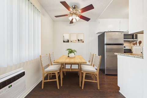 A dining room with a wooden table and chairs.