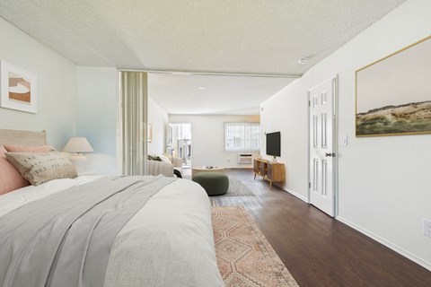 A bedroom with a large bed and a green chair.