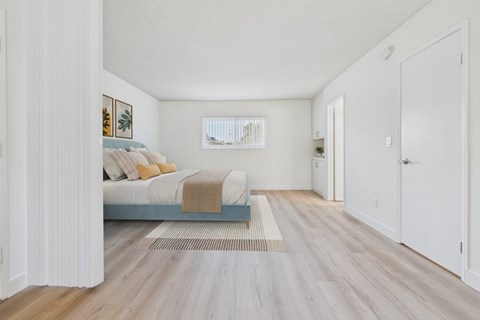 A bedroom with a bed and a rug in the middle of the room.