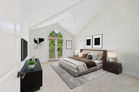 A bedroom with a large bed and a flat screen TV.