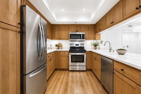 A modern kitchen with wooden cabinets and stainless steel appliances.