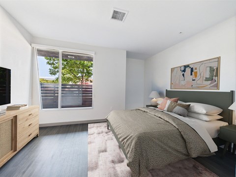 A bedroom with a large bed and a painting on the wall.