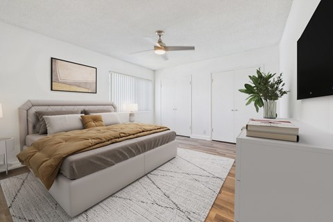 A bedroom with a large bed and a ceiling fan.