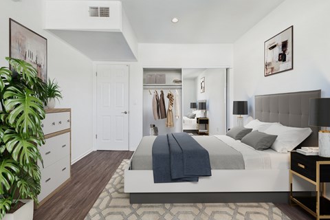 A bedroom with a large bed and a plant.