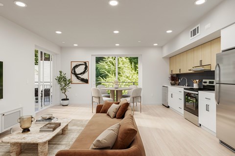 A modern living room with a brown sofa and a kitchen area in the background.