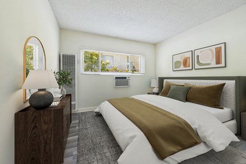 A bedroom with a large bed and a lamp on a wooden stand.