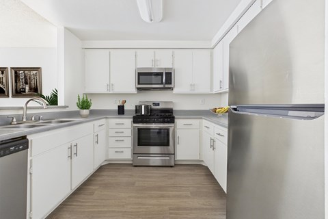 A modern kitchen with stainless steel appliances and white cabinets.