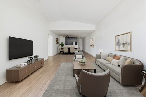 A living room with a grey rug and brown chairs.