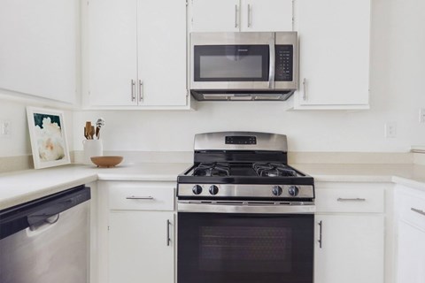 A modern kitchen with a stove, oven, and microwave.