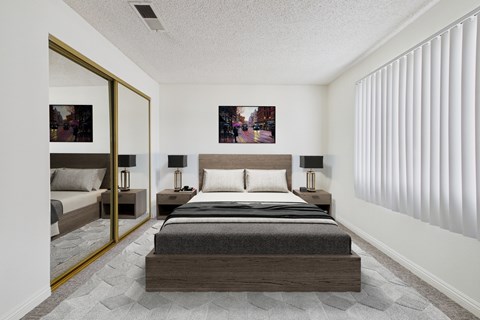 A bedroom with a large bed and a mirror on the wall.