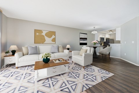 A living room with a white couch, a coffee table, and a painting on the wall.