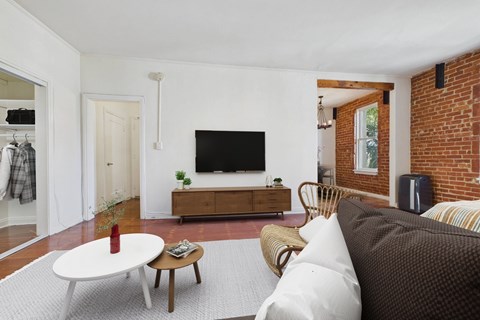 A living room with a white couch and a wooden coffee table.
