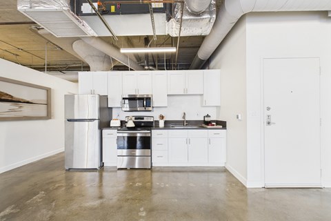 A modern kitchen with white cabinets and stainless steel appliances.